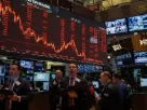 Traders in a busy room expressing concern over a cyberattack affecting the U.S. financial market.